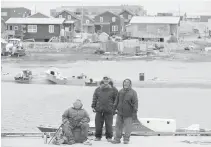  ??  ?? Residents watch as a cruise ship unloads tourists in the town of Gjoa Haven, Nunavut this month.