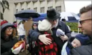  ?? GENE J. PUSKAR - THE ASSOCIATED PRESS ?? Rabbi Chuck Diamond, center, a former Rabbi at the Tree of Life Synagogue, hugs a woman after leading a Shabbat service outside the Tree of Life Synagogue, Saturday in Pittsburgh. Last Saturday, 11 people were killed and six wounded when their worship was interrupte­d by a gunman’s bullets.