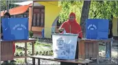  ??  ?? A woman drops her vote into a ballot box at a polling station in Nepalgunj in Kathmandu on Wednesday.