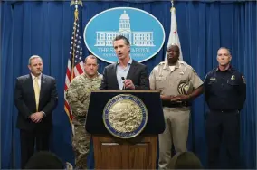  ?? AP PHOTO BY RICH PEDRONCELL­I ?? California Gov. Gavin Newsom, center, discusses his decision to withdraw several hundred National Guard troops from the nation’s southern border and changing their mission, during a Capitol news conference Monday, Feb. 11, in Sacramento, Calif.