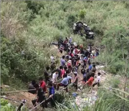  ?? , PHILIPPINE RED CROSS NUEVA VIZCA ?? Volunteers help survivors and retrieve victims from a passenger bus that fell in a ravine killing dozens in Carranglan township, Nueva Ecija province, northern Philippine­s on Tuesday.