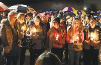  ?? Steve Kinderman / The Eau Claire Leader-Telegram ?? Mourners gather late Sunday for a candleligh­t vigil at Halmstad Elementary School in Chippewa Falls, Wis., in memory of the girls fatally struck by a driver the day before.