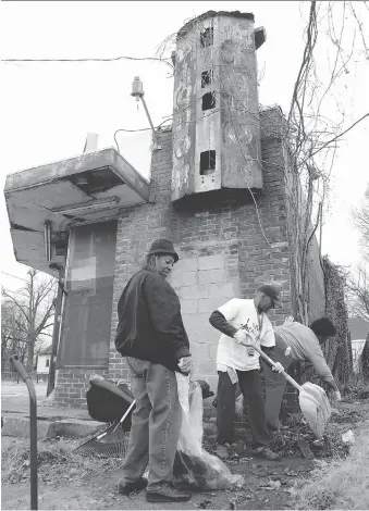  ?? MARK HUMPHREY/THE ASSOCIATED PRESS ?? Betty Taylor, left, and other volunteers help to clean up the grounds at an abandoned liquor store in Memphis, Tenn. Efforts like this are helping set Memphis apart in its fight against the blight epidemic, as city leaders try to maintain its tax base...