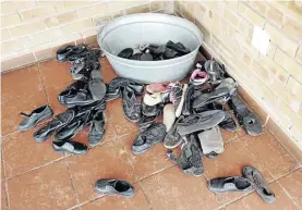  ??  ?? Pupils' shoes are placed in a corner while they play inside the school's premises.