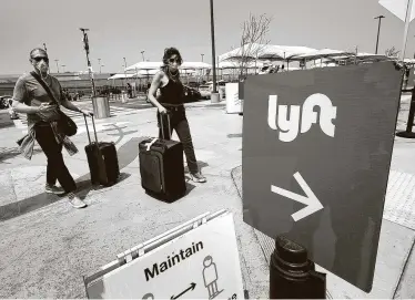  ?? Al Seib / Los Angeles Times ?? In an undated photograph, passengers make their way to the ride-share location at Los Angeles Internatio­nal Airport as Uber and Lyft drivers held a rally.