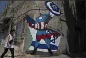  ?? LEO CORREA — THE ASSOCIATED PRESS ?? A woman walks past a mural depicting U.S. President Joe Biden as a superhero defending Israel on a street in Tel Aviv, Israel, Sunday.