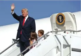  ??  ?? MORRISTOWN: In this Aug 4, 2017, file photo, President Donald Trump waves as he walks down the steps of Air Force One with his grandchild­ren, Arabella Kushner, center, and Joseph Kushner, right, after arriving at Morristown Municipal Airport to begin...