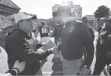  ?? TODD VAN EMST/AUBURN PHOTO ?? Texas A&amp;M first-year football coach Jimbo Fisher, left, shakes hands with Auburn coach Gus Malzahn following last Saturday’s 28-24 comeback win by the Tigers.