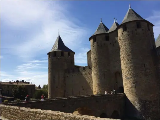  ?? ALINA HARTOUNIAN PHOTOS, THE ASSOCIATED PRESS ?? Tourists enter the Comtal Chateau, a fortificat­ion within the walls of the medieval city of Carcassonn­e, France. Carcassonn­e is a castle-on-the-hill getaway in the south of France