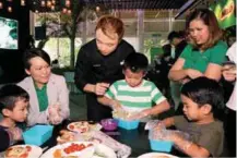  ??  ?? Kids working on their creative breakfasts with the help of their parents and Chen (in black).