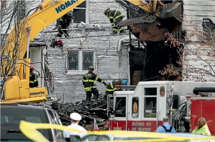  ?? PHOTOS: REUTERS ?? Baltimore officials remove a sheet covered stretcher from the scene of a overnight house fire where several children died and others including the mother were injured.