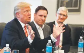  ??  ?? Apple CEO Tim Cook, right, and PayPal founder Peter Thiel, center, listen as President-elect Donald Trump speaks Wednesday during a meeting with tech industry leaders at Trump Tower in New York. Evan Vucci, The Associated Press