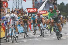  ?? The Associated Press ?? GO FOR GREEN: Peter Sagan, right, crosses the finish line Friday while wearing the best sprinter’s green jersey to win the 13th stage of the Tour de France, which covered 105.3 miles from Bourg d’Oisans to Valence, France.