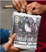  ?? — AFP ?? Help at hand: A volunteer collecting donations for Kerala flood victims on a street in Mumbai.