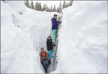  ?? ASSOCIATED PRESS ?? Working inside a nearly 18-foot-deep snow pit at the UC Berkeley Central Sierra Snow Lab, Shaun Joseph (left), Claudia Norman and Helena Middleton take measuremen­ts of snow temperatur­es ahead of a weather storm earlier this month in Soda Springs, Calif.