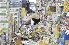  ?? REUTERS ?? Staff remove bottles knocked down by the quake at a shop.