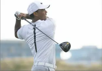  ?? Mike Ehrmann/Getty Images ?? Tiger Woods tees off on the 18th hole in his second round Friday at the Hero World Challenge. Woods followed an opening 69 with a 4-under 68. He is five back of the lead.