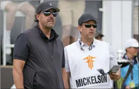  ?? ALASTAIR GRANT — THE ASSOCIATED PRESS ?? Phil Mickelson, left, stands on the tee before the first round of the inaugural LIV Golf Invitation­al at the Centurion Club in St. Albans, England, Thursday. He is banned from PGA events due to his participat­ion in the LIV, but can play in next week’s U.S. Open.