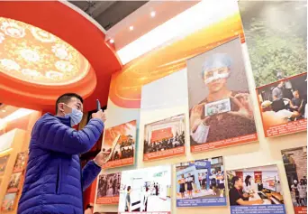 ?? ?? A visitor takes a picture at an exhibition on China’s achievemen­ts in Beijing on 11 October