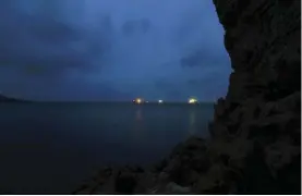  ?? ?? Bunkering ships as seen from the Yelkouan Shearwater breeding cave where a study on the effect light pollution has on seabird colony attendance took place. (Photo by Benjamin Metzger)