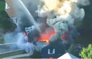  ?? WCVB FILE VIA AP ?? Flames consume the roof of a home following an explosion Sept. 13 in Lawrence, Mass. Columbia Gas of Massachuse­tts and its parent, NiSource Inc., announced Monday that a settlement had been reached in class-action lawsuits resulting from the disaster across several towns north of Boston.