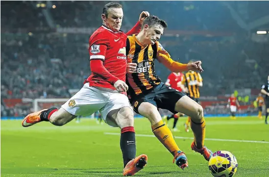  ?? Picture: REUTERS ?? FLYING HIGH: Hull City's Andrew Robertson challenges Manchester United's Wayne Rooney, left, during their match at Old Trafford in Manchester yesterday