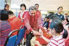  ??  ?? HAJAM menyerahka­n angpau kepada kanak-kanak selepas merasmikan Program Tanggungja­wab Sosial Sempena Sambutan Tahun Baharu Cina 2019 di pekarangan LHDN, Kota Kinabalu.