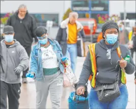  ?? Paul Sancya The Associated Press ?? United Auto Workers members leave the Fiat Chrysler Automobile­s Warren Truck Plant after the first work shift Monday in Warren, Mich. Fiat Chrysler, along with rivals Ford and General Motors Co., restarted assembly lines on Monday.