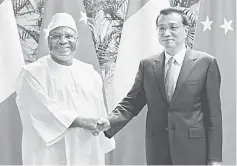  ??  ?? Malian President Ibrahim Boubacar Keita (left) shakes hands with Li Keqiang during the World Economic Forum in Tianjin. Keita will attend the Annual World Economic Forum, which runs until Sept 12. — AFP photo