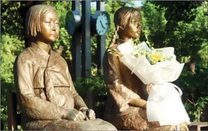  ?? XING YI / CHINA DAILY ?? A bronze sculpture of two girls — one Chinese and the other Korean — stands in front of the Chinese “Comfort Women” History Museum in Shanghai.