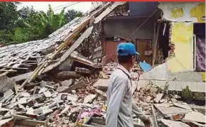  ?? AFP PIC ?? A man looking at damaged houses following an earthquake in Selong, Lombok, yesterday.