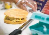  ?? SETH WENIG/AP 2022 ?? A breakfast sandwich is prepared in New York. The Hilton hotel chain says in a trends report that “free breakfast” is the most used search query on its website.