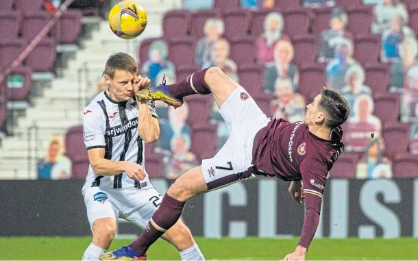  ??  ?? OVERHEAD KICK: Hearts’ Jamie Walker, who scored the only goal of the game, puts in an acrobatic challenge on Lewis Mayo of Dunfermlin­e.