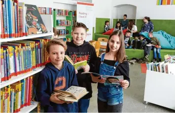  ?? Foto: Judith Roderfeld ?? Hier, in der St. Georg Volksschul­e, entstand 2010 die erste Leseinsel – nun wurde dort Bilanz gezogen. Mittlerwei­le haben zehn Schulen in Augsburg die modernen Büchereien. Luis (11), Andreas (11) und Sandra (11) (von links) schauen in die Bücher der...