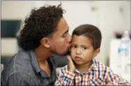  ?? RUBEN R. RAMIREZ/THE EL PASO TIMES VIA AP ?? Roger Ardino 24, gives his son Roger Ardino Jr., 3, a kiss on the cheek shortly after speaking to reporters at a news conference at the Annunciati­on House in El Paso, Texas, Wednesday, July 11, 2018. Ardino and Pablo Ortiz, 28, and his son Andres 3,...