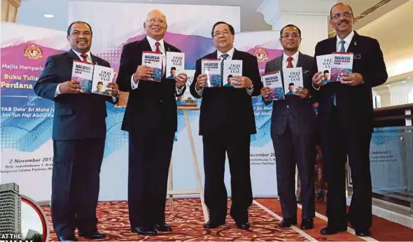  ?? PIC BY MOHAMAD SHAHRIL BADRI SAALI ?? Prime Minister Datuk Seri Najib Razak with the two books he launched at the Parliament building in Kuala Lumpur yesterday. With him are (from left) Minister in the Prime Minister’s Department Datuk Seri Jamil Khir Baharom, Religious Adviser to the...