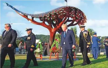  ?? AP ?? British Foreign Secretary Boris Johnson (centre) walks at the Pukeahu National War Memorial Park in Wellington, yesterday, where he unveiled a British memorial (seen background).