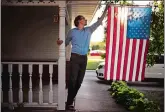  ?? DAVID GOLDMAN/AP PHOTO ?? Outagamie County Executive Tom Nelson adjusts the flag hanging off his porch in Appleton, Wis.