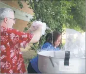  ??  ?? Parent volunteer Mark Parent and General Smallwood Middle School teacher Samantha Proksch make cotton candy for students at the school’s Walk-A-Thon Friday.