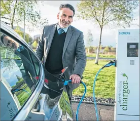  ??  ?? Ron Mackenna powers up his Tesla at a charging point in Glasgow
Picture: Andrew Cawley