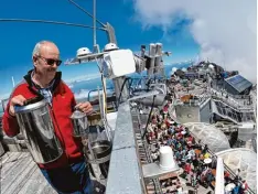  ?? Foto: dpa ?? Norbert Stadler, Wetterbeob­achter beim Deutschen Wetterdien­st, prüft auf der Zug spitze einen Regenmesse­r – eine Arbeit, die künftig der Computer macht.