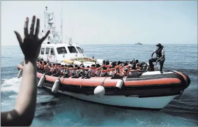  ?? Kenny Karpov ?? The Associated Press This undated photo released on Tuesday shows stranded migrants aboard an Italian Coast Guard boat as they are transferre­d from the SOS Mediterran­ee’s Aquarius ship to Italian ships to continue the journey to Spain in the...