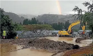  ?? PHOTO: NARDIA WEEDS ?? A digger sits in floodwater as it clears debris left on Roxburgh’s streets after flash flooding hit the area on Sunday afternoon.