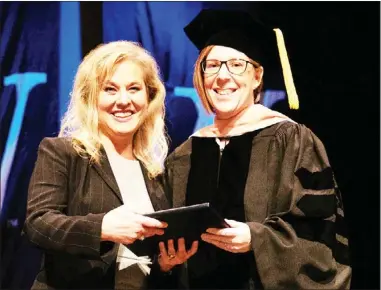  ?? ?? Two-time nursing graduate Stephanie Mclain Gale presents the Mclain Family Award for Extraordin­ary Faculty to Dr. Alena Groves at Spring Commenceme­nt. (Submitted photo)