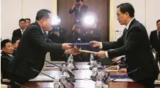  ?? FOTO: DPA ?? Südkoreas Wiedervere­inigungsmi­nister Cho Myoung Gyon (rechts) und der nordkorean­ische Außenminis­ter Ri Son Gwon tauschen Akten aus.