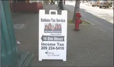  ?? DANIELLE VAUGHN/NEWS-SENTINEL ?? A sign advertises a tax business on Elm Street in Downtown Lodi on Monday.