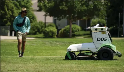  ?? MATTHEW JONAS — STAFF PHOTOGRAPH­ER ?? Operations Lead Kevin Mcglade supervises as a Scythe electric autonomous lawn mower cuts grass on July 12in a large grassy area near Button Rock Drive in Longmont. Scythe Robotics Inc. is settling into its new Longmont headquarte­rs.