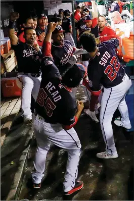  ?? ASSOCIATED PRESS ?? ABOVE: WASHINGTON NATIONALS’ Victor Robles celebrates with teammates after hitting a home run during the sixth inning of Monday’s game against the St. Louis Cardinals in Washington. LEFT: St. Louis Cardinals’ Marcell Ozuna can’t catch a ball hit by Washington Nationals’ Anthony Rendon during the third inning of Monday’s game in Washington. Adam Eaton scored on the play.