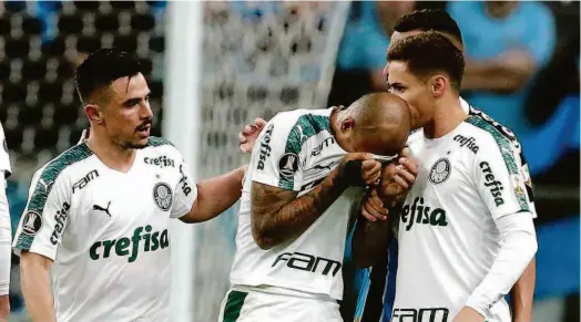  ?? Diego Vara/reuters ?? Consolado pelo atacante Willian (à esq.) e o meia Raphael Veiga, o volante Felipe Melo chora após ser expulso na partida contra o Grêmio, pela Libertador­es; o técnico Felipão defendeu o seu jogador e considerou injusta a decisão do árbitro argentino Patricio Loustau