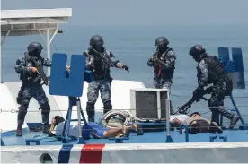  ??  ?? Philippine and Japanese Coast Guard personnel conduct a drill on board a Philippine Coast Guard boat during their annual anti- piracy exercise in the waters off Manila Bay on Wednesday.